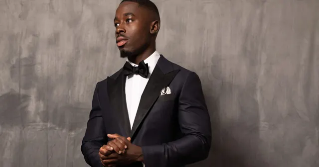 Kobe Apponsah in a midnight bespoke tuxedo with satin peak lapels and bow tie