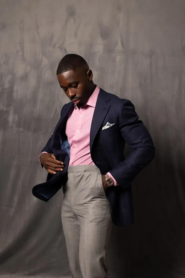 Client in a navy custom jacket and pink shirt adjusting the lining