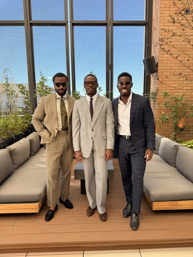 Clients wearing custom tailoring in tan, beige and navy check on a rooftop terrace