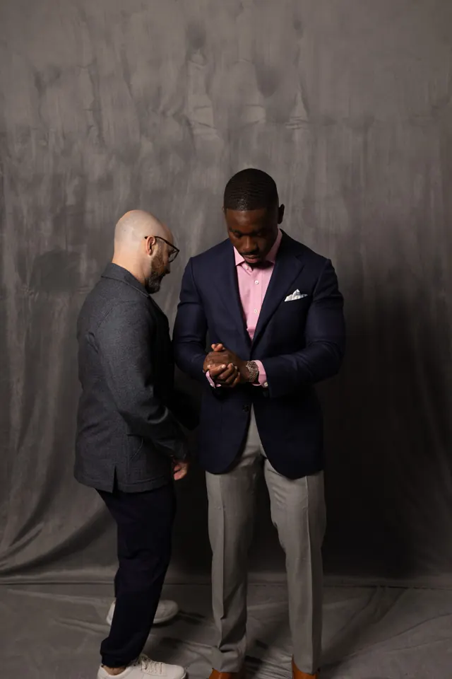 Kobe Apponsah fitting a client in a navy bespoke suit jacket with pink shirt in Salt Lake City