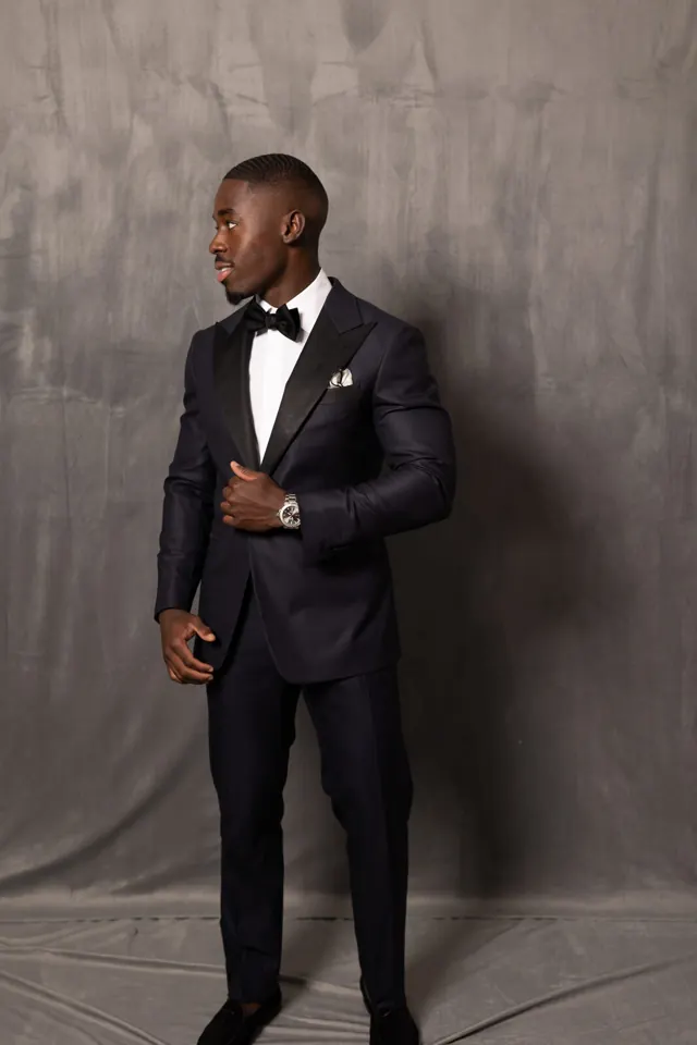 Kobe Apponsah wearing a bespoke midnight tuxedo with silk peak lapels and bow tie